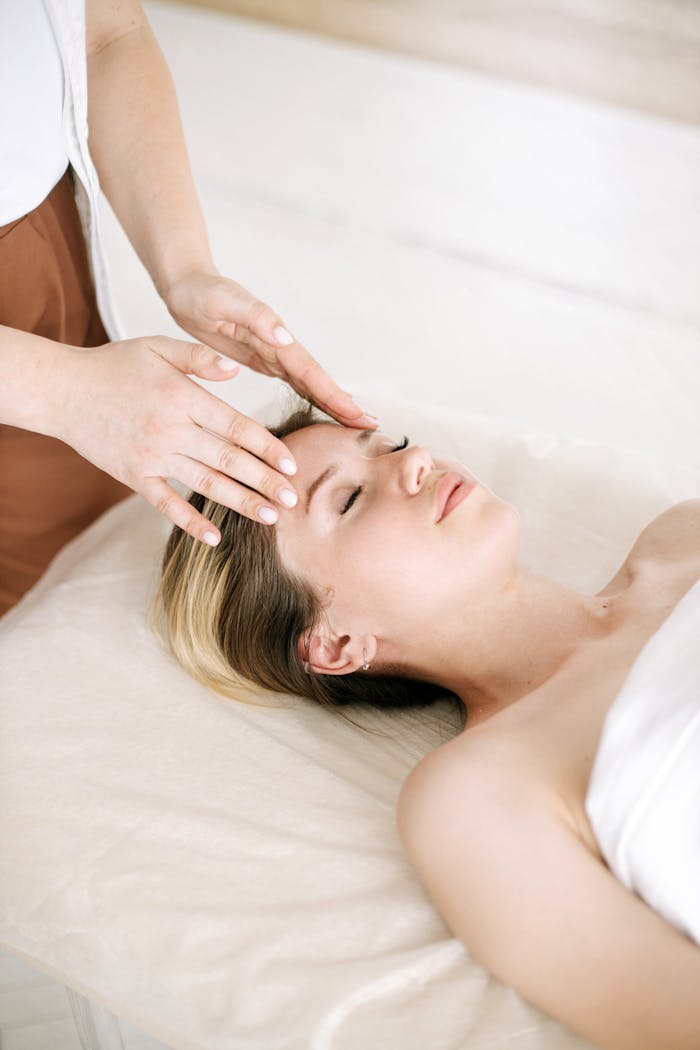 A woman enjoys a relaxing face massage at a spa, promoting well-being.